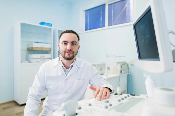 Médico varón con equipo ultrasónico durante el examen médico por ultrasonido — Foto de Stock