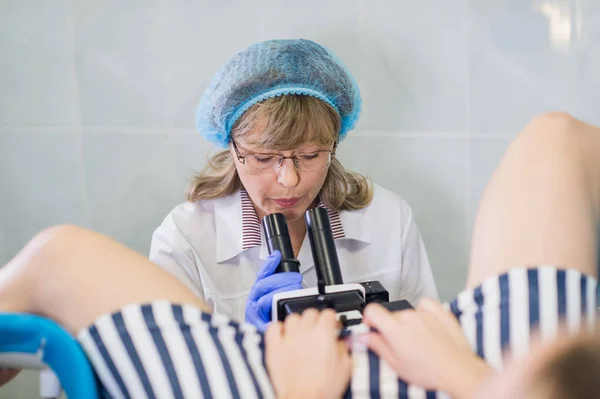 Senior female positively gynecologist examining a patient at clinic, health care concept Royalty Free Stock Photos