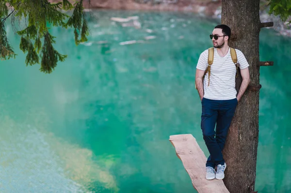 Bebaarde man model vormt samen met een groene water Lake. — Stockfoto