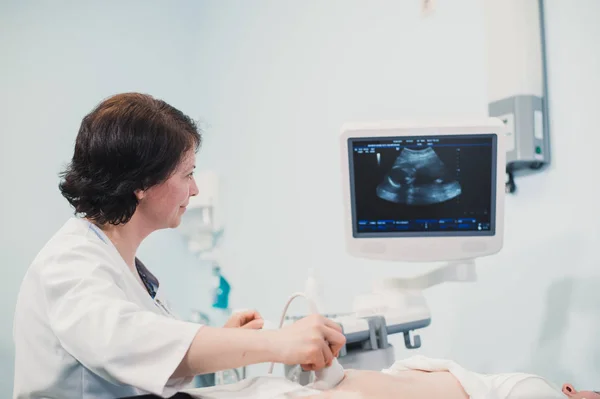 Médico mostrando imagem de ultra-som do bebê no computador para mulher grávida — Fotografia de Stock