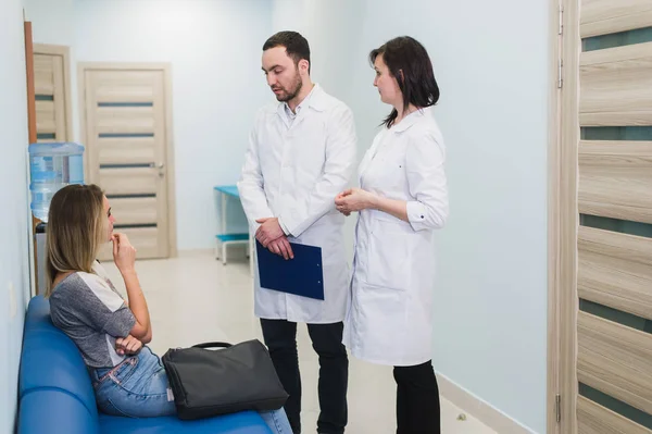 Paciente femenina siendo reasegurada por médicos en habitación de hospital — Foto de Stock