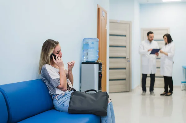 Paziente donna a parlare al cellulare in sala d'attesa dell'ospedale . — Foto Stock
