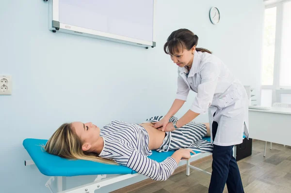 Arzt untersucht den Magen einer ihrer Patientinnen — Stockfoto