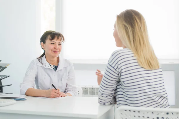 Amable médico femenino reconfortante paciente de mediana edad en el hospital — Foto de Stock