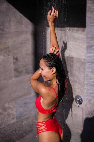 Vrouw onder douche op het strand na het zwemmen — Stockfoto