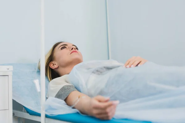 Zamyšlená žena transfuzi, ležící v nemocnici oddělení — Stock fotografie