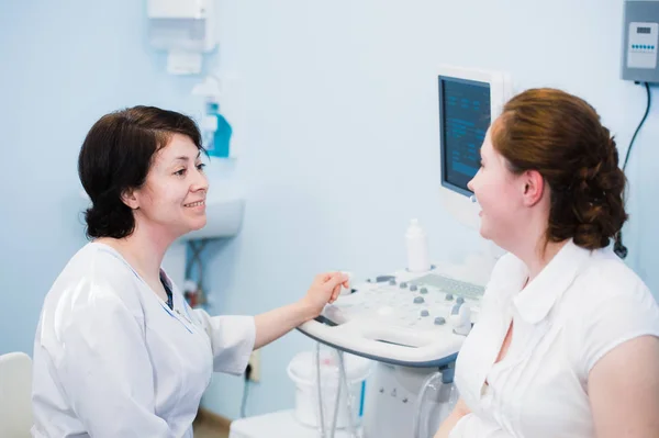 Satisfait femme enceinte ayant rendez-vous chez le médecin avec des diagnostics échographiques — Photo