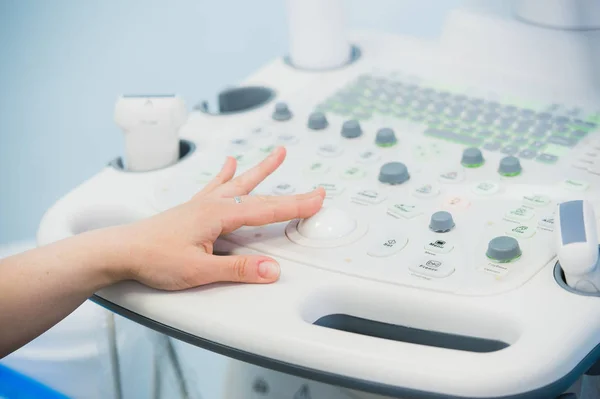 Ung kvinna läkare händerna närbild förbereder för en enhet ultraljudsundersökning. — Stockfoto