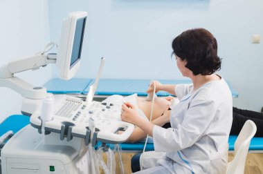 Ultrasonda genç hamile kadın, sağlık kontrolü ile doktor