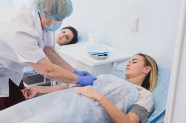 Hemşire hastane odasında bir intravenöz damla bağlanma.
