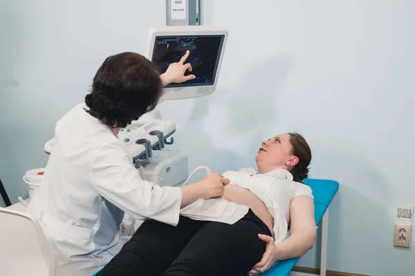 Médecin utilisant l'échographie et le dépistage de l'estomac de la femme enceinte . — Photo