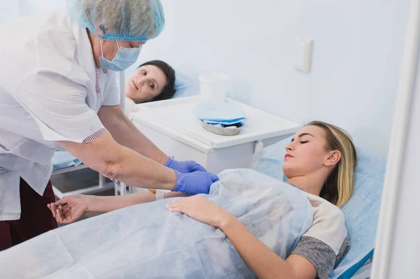 Enfermeira conectando um gotejamento intravenoso no quarto do hospital . — Fotografia de Stock