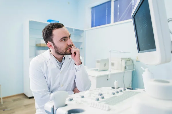 Retrato de un médico pensante cerca de esceen de equipo médico . — Foto de Stock