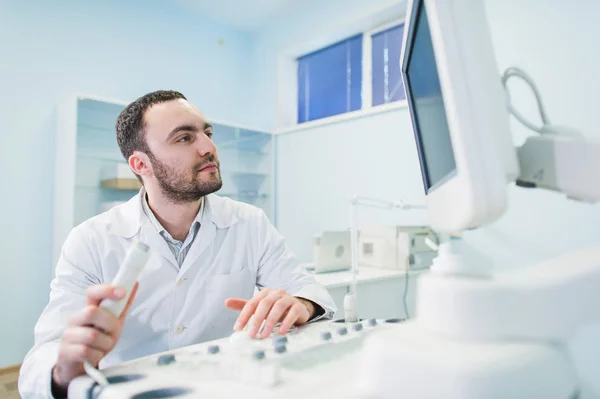 Mannelijke arts met ultrasone apparatuur tijdens echografie medisch onderzoek — Stockfoto