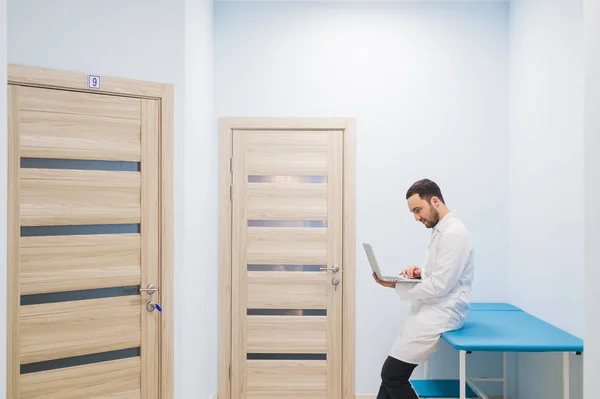 Médecin spécialiste dans le couloir de sa clinique avec son ordinateur portable — Photo