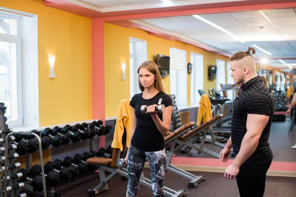 Donna con il suo personal fitness trainer in palestra che esercita la ginnastica di potenza con un bilanciere — Foto Stock