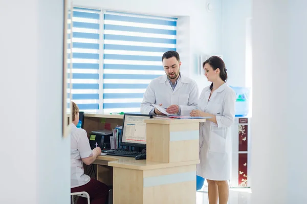 Recepción ocupada en un hospital con médicos y recepcionistas — Foto de Stock