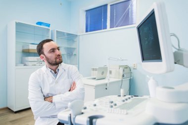 Tıbbi ekipman sceen yakınındaki bir düşünme doktor portresi.