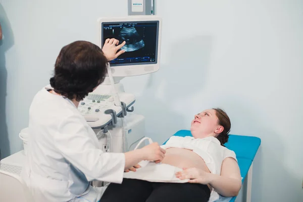 Arts met behulp van echografie en screening van de buik van zwangere vrouw. — Stockfoto
