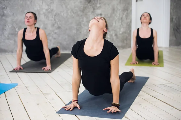 Jóvenes trío deportivo grupo de chicas están practicando ejercicios de yoga en el estudio — Foto de Stock