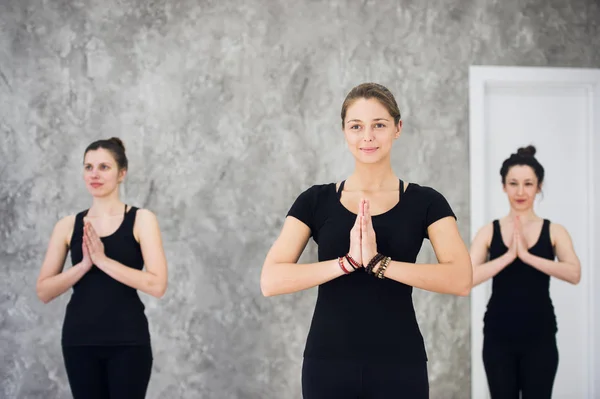 Молода спортивна тріо група дівчат практикує вправи з йоги в студії — стокове фото