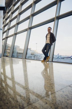 olacak birazdan. Havaalanı lounge'uçağı için beklerken konuşan gülen yakışıklı bir genç adam portresi