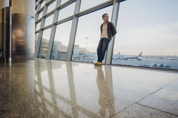 Portrait of an attractive young man walking and looking at mobile phone — Stock Photo, Image