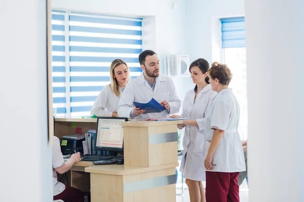 Médico y recepcionista en recepción en un hospital — Foto de Stock