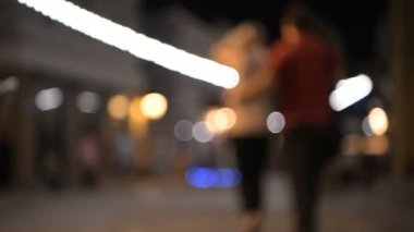 Gece City geziniyor ve sarılma iki kişi ile sokak ışıkların arka plan bulanık