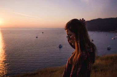 Yaz güneşli yaşam tarzı moda portre sevimli trendy kıyafeti giymiş dağlarda, yürüyen genç şık hipster kadın hafta sonları, zevk gülümseyen seyahat sırt çantası ile. Muhteşem okyanus manzarası üzerinde bir