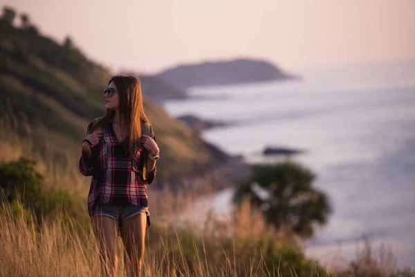 Молодая женщина свободы наслаждается закатом океана на вершине горы — стоковое фото