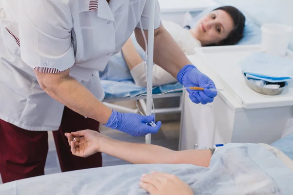 Sjuksköterska ansluter ett intravenöst DROPP i sjukhussal. — Stockfoto