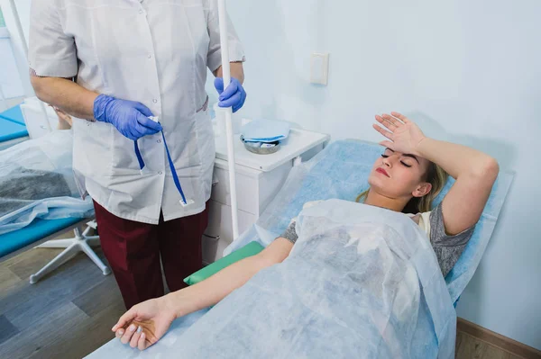 Professionelle Krankenschwester, die einer Frau, die im Krankenhaus auf dem Operationstisch liegt, eine Spritze verabreicht, um ein Konzept für eine Operation unter Narkose vorzubereiten. — Stockfoto