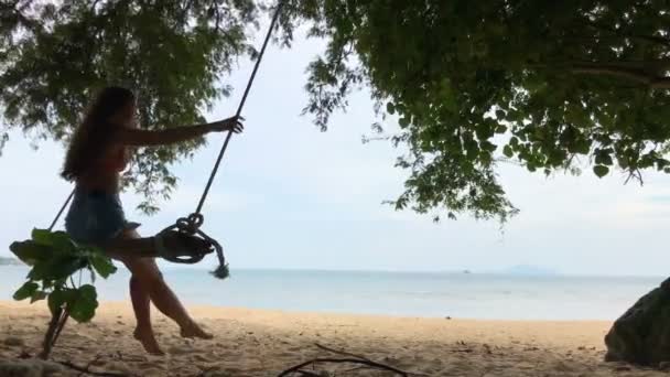 Mujer balanceándose en la playa tropical, día soleado, buen tiempo. Balanceo en isla paradisíaca . — Vídeos de Stock