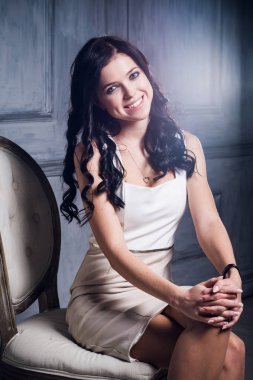 Kız bir sandalyede oturuyor ve gülümseyen bir zarif beyaz elbise gülüyor. Lens flare sanat etkisi