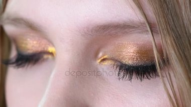 Mavi kadın göz güzel altın tonları makyaj ile görünümünü kapatın. Klasik makyaj. Mükemmel bir şekil makyaj ve uzun kirpikler. Kozmetik ve makyaj. Closeup makro moda gözleri sima vurdu