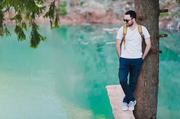 Bebaarde man model vormt samen met een groene water Lake. — Stockfoto