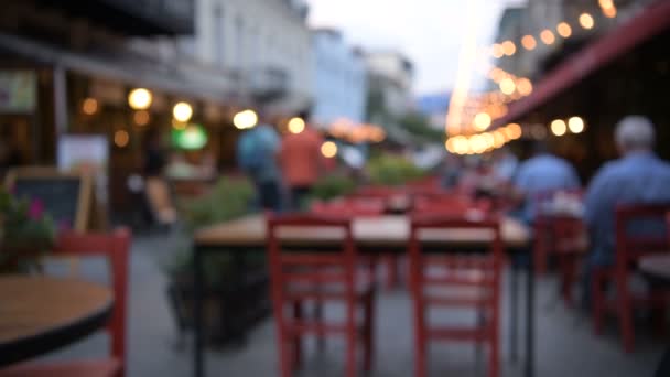 The Bar or cafe on the Street outdoors at Night in the City of Tbilisi, Georgia. Blur Background with Bokeh Effects, lights and people walking around. Abstract video for use as a background — Stock Video