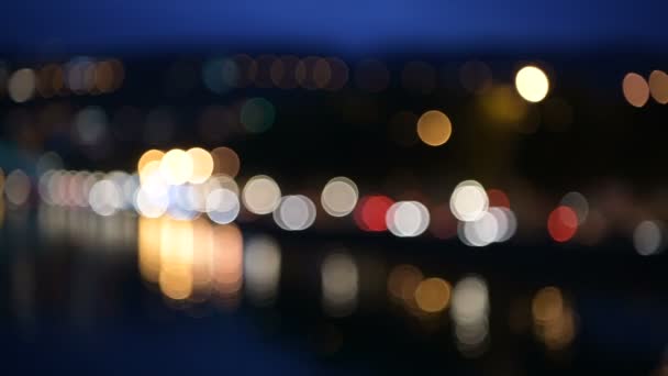 Desenfocado camino de la ciudad de noche: río, puente, coches en movimiento y farolas. Hermosa noche bokeh paisaje — Vídeos de Stock