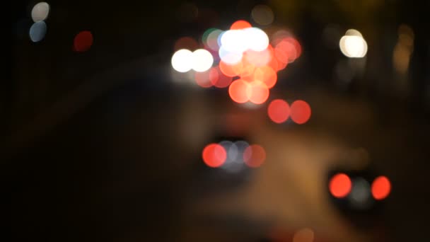 Светлая ночная раскраска боке размывает художественный фон. Автомобили горят на дороге — стоковое видео