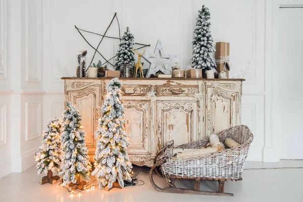 Decoración de Navidad en la antigua cómoda antigua vintage de cajones. Regalos artesanales hechos a mano, velas y un árbol al fondo. — Foto de Stock