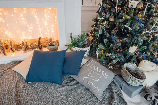 Julgran på trägolv i vit inredning. Julgran dekorerar med konstgjorda blommor, kransar och jul leksaker — Stockfoto