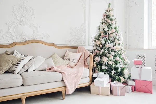 Vánoční stromeček s bílou pohovkou v bílé místnosti. — Stock fotografie