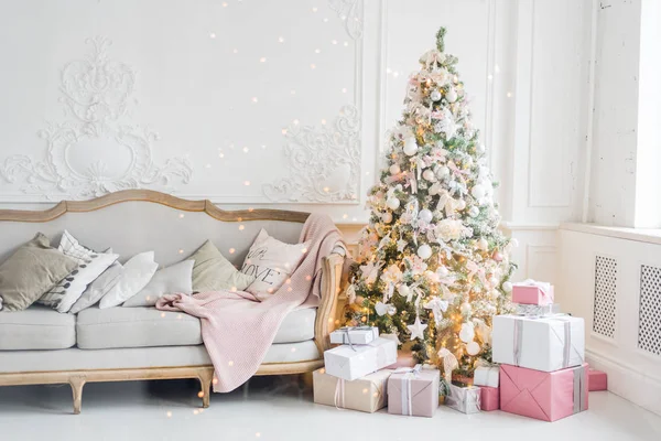 Silvester Urlaub oder Feier, die Stimmung, stilvolle Weihnachten minimalistischen Interieur, Geschenke und verpackte Geschenke unter dem Weihnachtsbaum. großes weißes Wohnzimmer mit Vintage-Sofa — Stockfoto