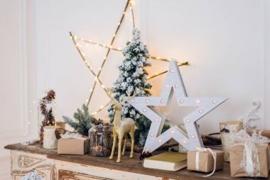 Noel süslemeleri, oyuncak geyikler, yıldızlar ve ışık arka planında hediye kutuları. yumuşak odak, bulanık arkaplan