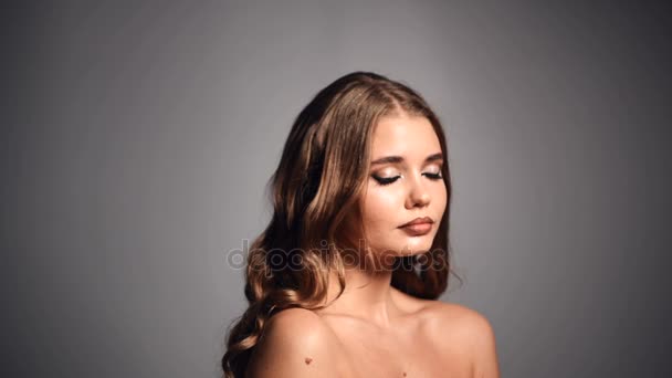 Portrait of beautiful young fashion woman, she looking at camera, smiling and blinking with one eye — Stock Video