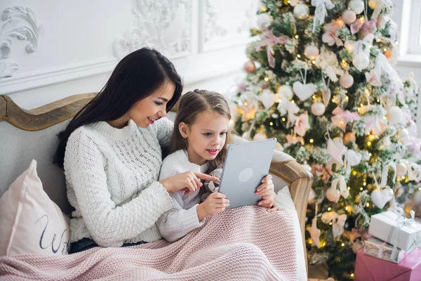 Hermosa joven y su hija con la tableta en Navidad. Primer plano. — Foto de Stock