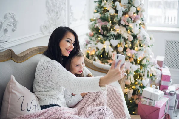 Mano bien arreglada de una mujer sosteniendo un teléfono tomando una selfie con su hija, niña —  Fotos de Stock