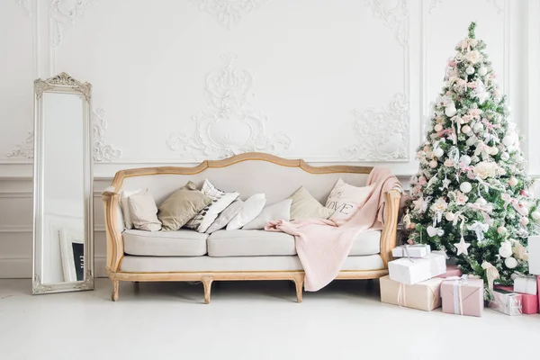 Árbol de Navidad con un sofá blanco en una habitación blanca . —  Fotos de Stock