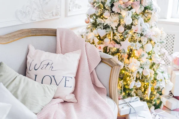 Weihnachts- oder Neujahrsdekoration im Wohnzimmer- und Ferienhaus-Dekorationskonzept. Ruhiges Bild von Decke auf einem Vintage-Sofa mit Baum, Lichtern, Geschenken. Selektiver Fokus — Stockfoto